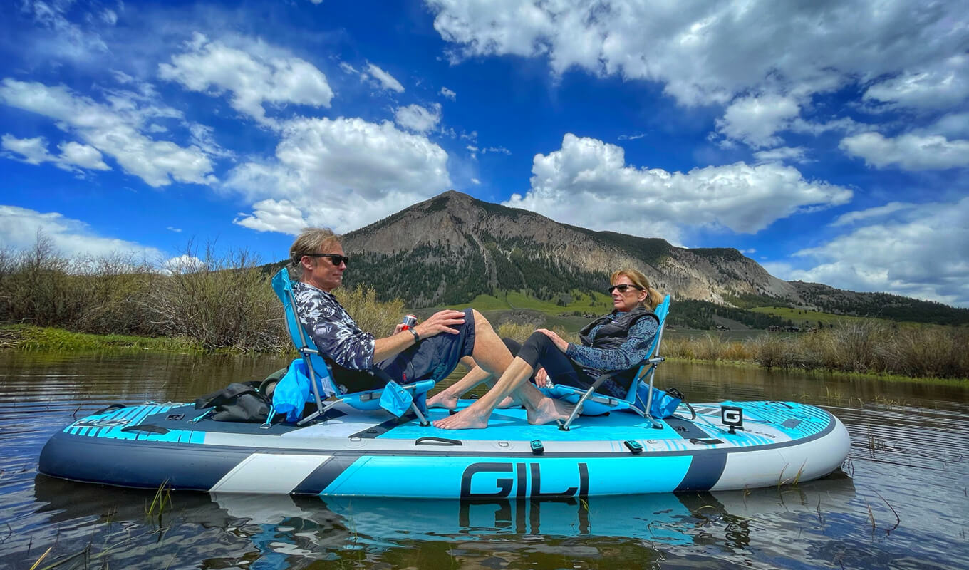 Couple relaxing on a manta inflatable paddle board