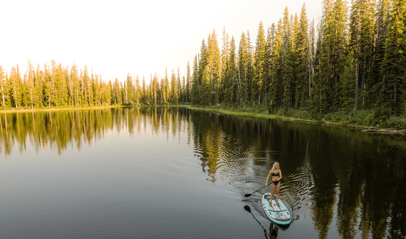 Woman paddle boarding on lake