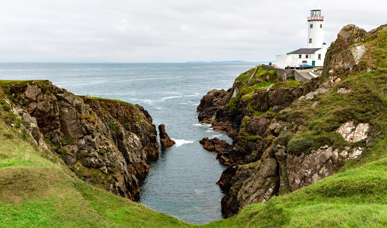 White lighthouse near a calm water on a cove