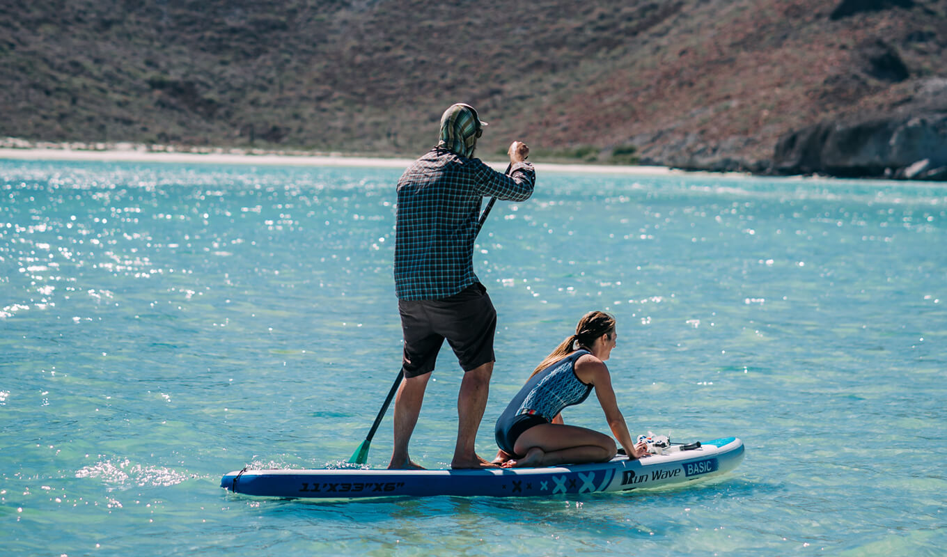 Man and woman paddle boarding in Mexico