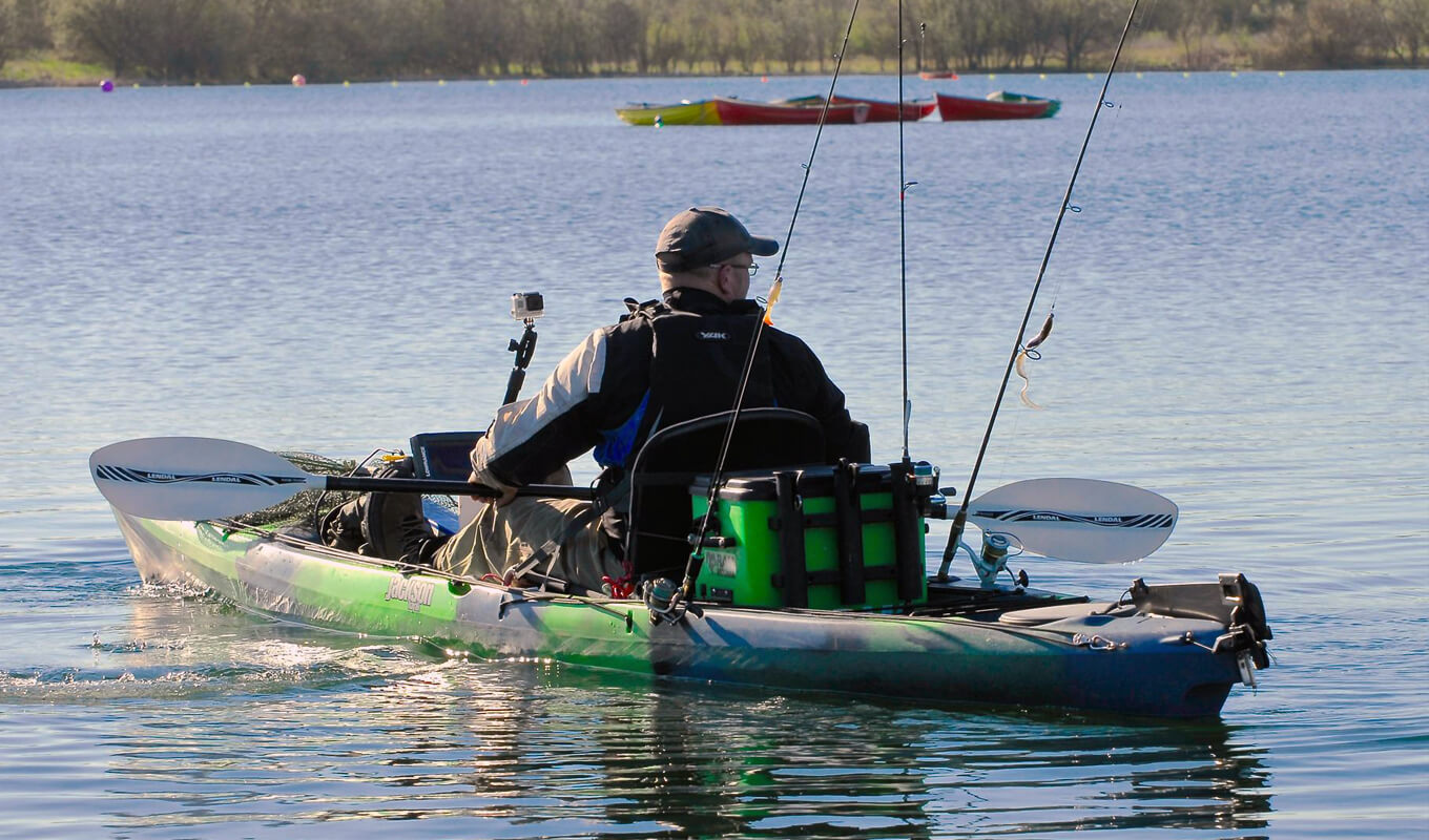 Man fishing on a green kayak with a pedal