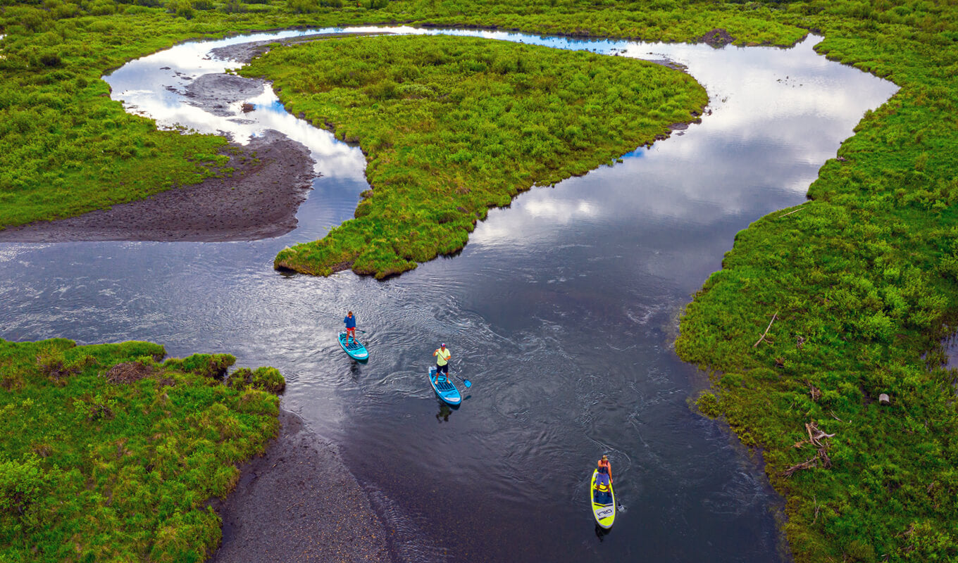 Paddle boarders on a calm river rapids