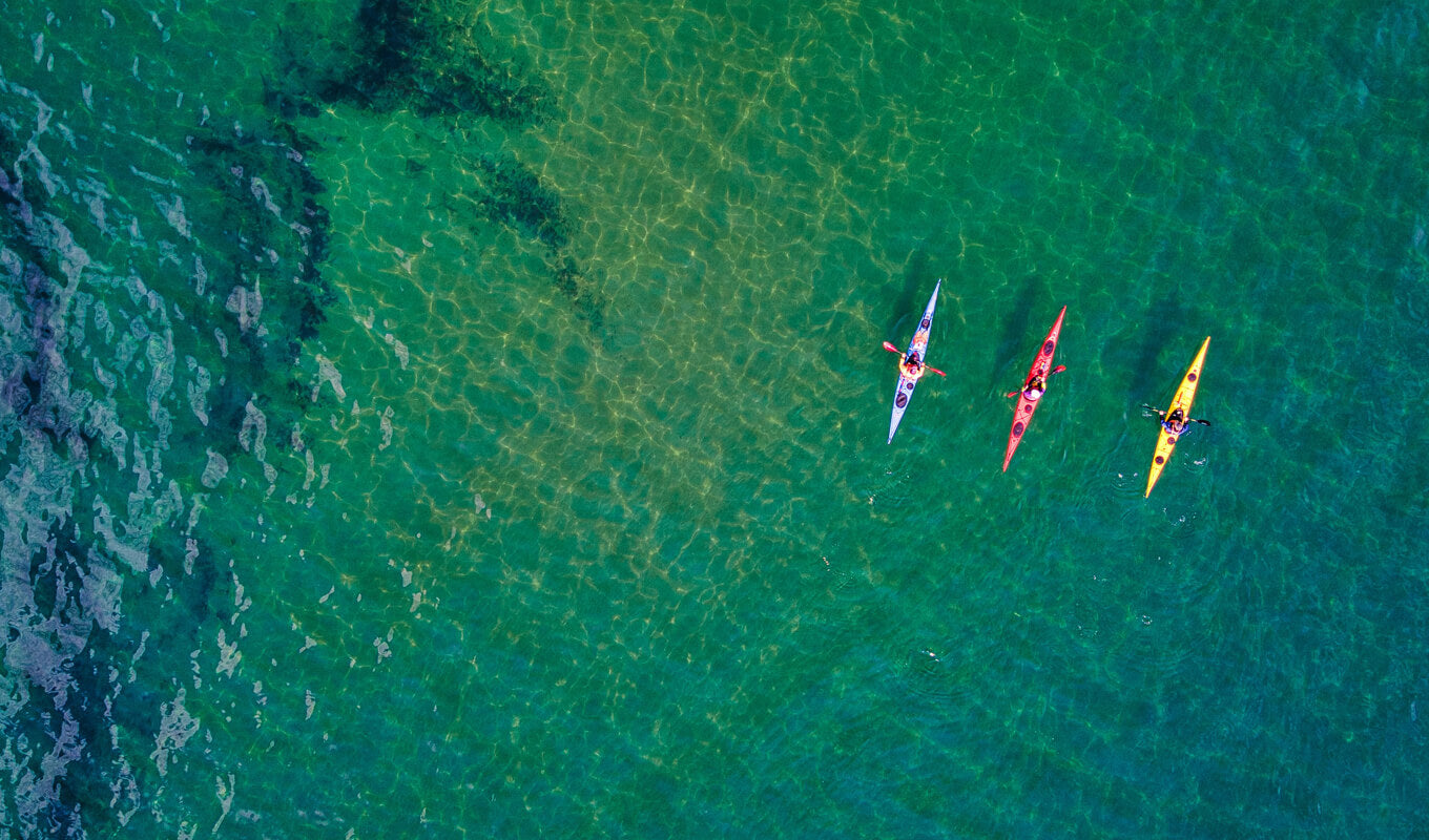 Red, yellow and blue kayak in the ocean