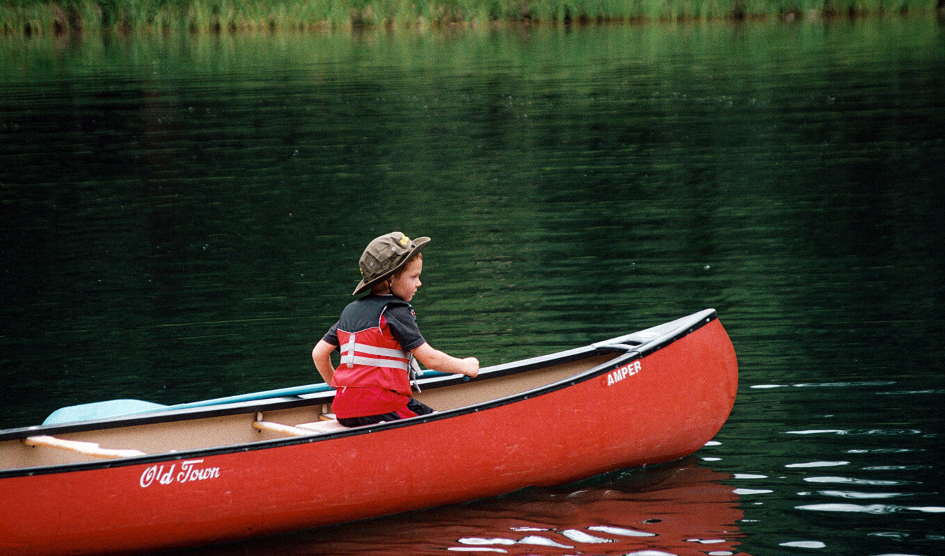 Kid on an Old town square stern canoe