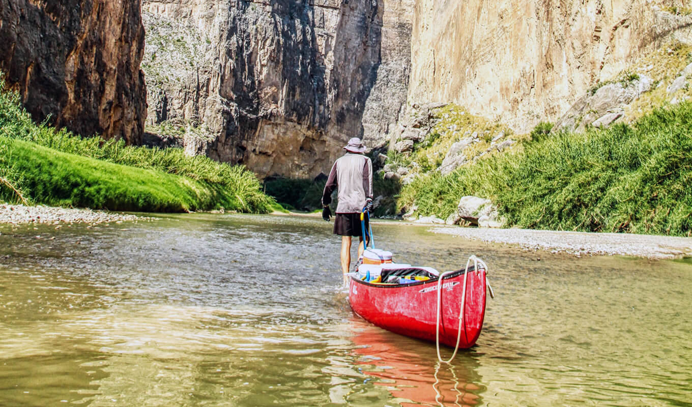 Man pulling his red canoe