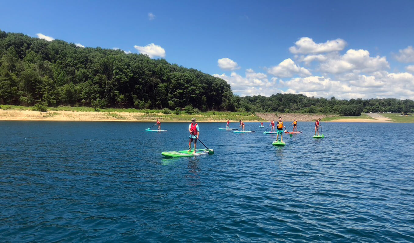 Paddle board instructor with his students on paddle board