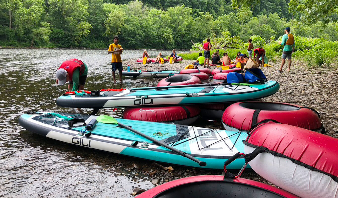 Studenten-Sommercamp mit GILI-Paddelbrettern an einem Fluss