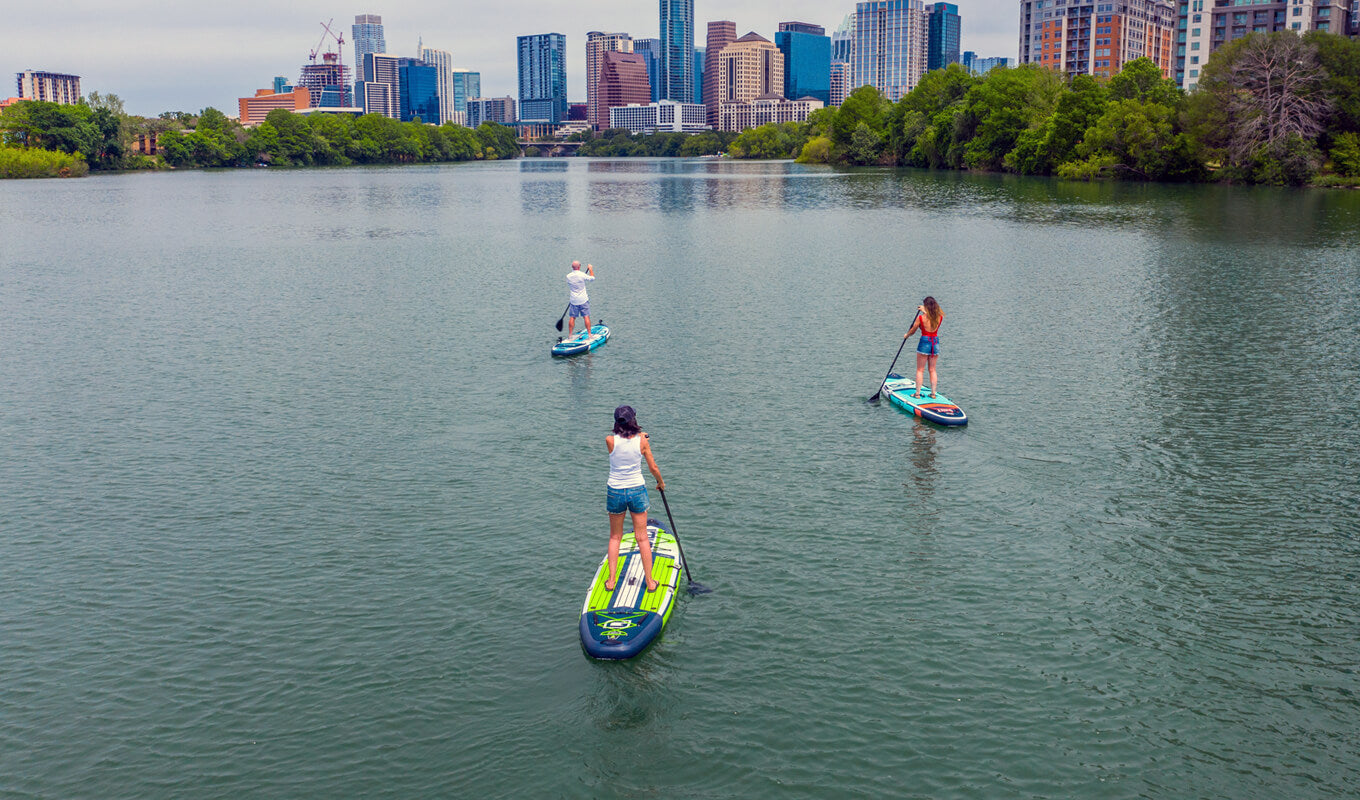 Man and a woman paddle boarding on a lake