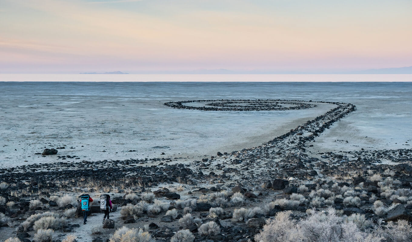 Man and a woman paddle boarding in spiral jetty