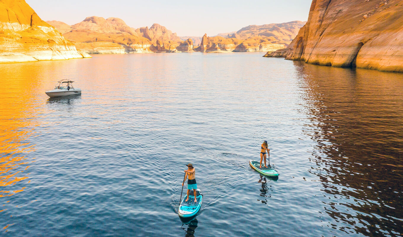 Man and a woman paddle boarding in lake powell