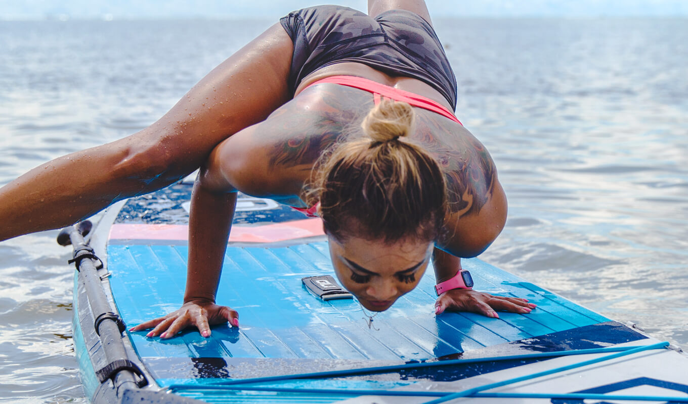 Woman performing a Crow pose on a komodo inflatable paddle board