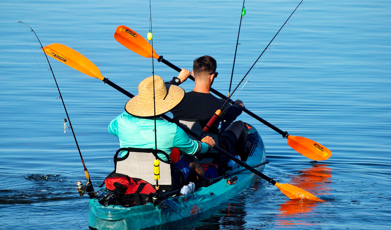 Two person on a tandem kayak fishing on the lake