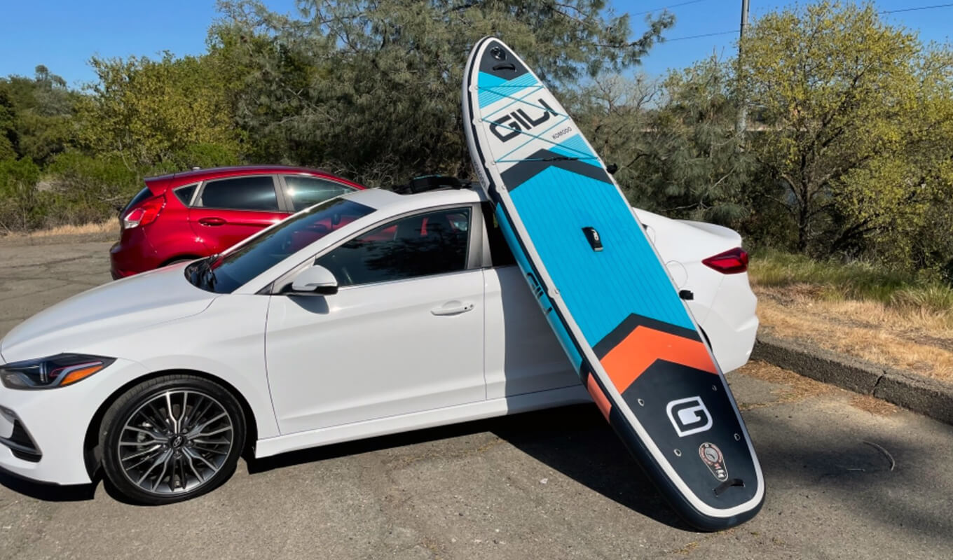 Komodo inflatable paddle board lean on a car