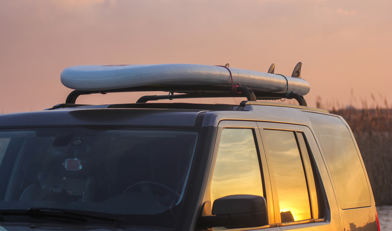 Paddle board strap on a car roof rack