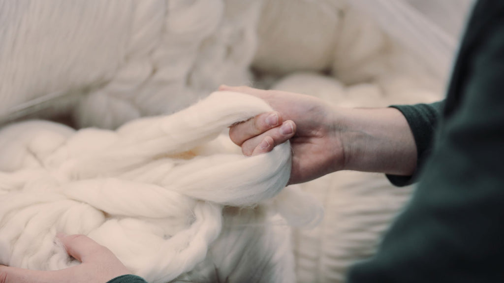 hand of a woman pulling wool