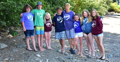 a grandma with grandchildren all standing on the beach in coordinating Shuswap Soul t-shirts