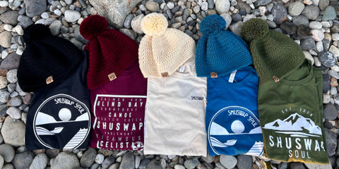 Five tshirts and coordinating made in canada toques are laid out on the ground