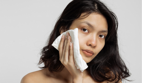 A woman exfoliating her skin with a cloth