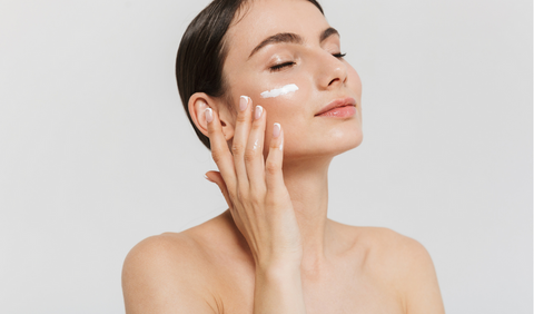 Woman moisturizing her skin for summer