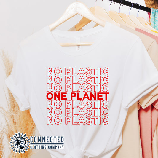 No Plastic One Planet Tshirt hanging on a clothing rack - sweetsherriloudesigns - Ethical and Sustainable Apparel - 10% of proceeds donated to ocean conservation