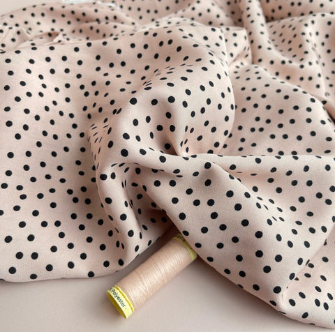 Image of pale pink fabric with small black dots