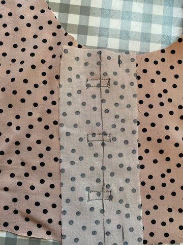 Rectangles drawn on the back of pale pink polka dot fabric
