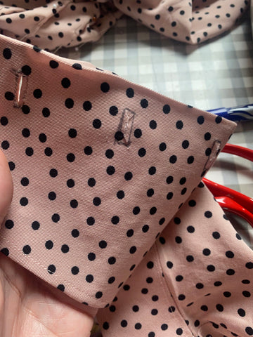 Image of rectangles drawn onto pale pink polka dot fabric with small snips in the middle
