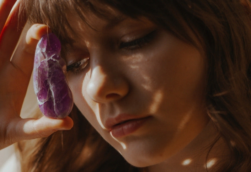 woman holding amethyst crystal