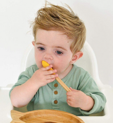 baby with yellow bamboo spoon from babynow