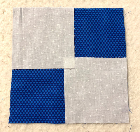 Laying two small squares on top of a large square to make the flying geese