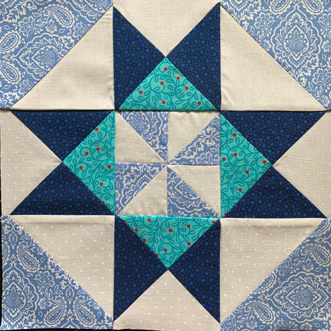 Grandma's Pinwheel quilt block made with half square triangles and quarter square triangles in blue