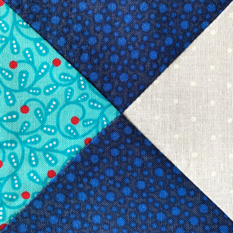 Quarter Square Triangle Block in blue, white and teal.