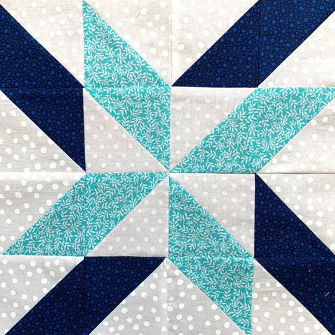 Trailing Star Quilt Block made with teal, blue, and white half square triangles