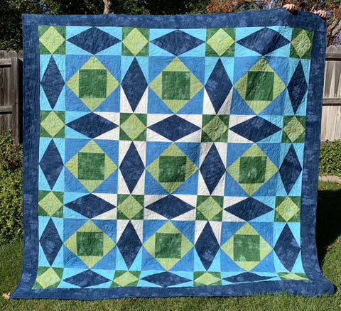 My finished Tsunami Quilt in green, blue, navy, and white