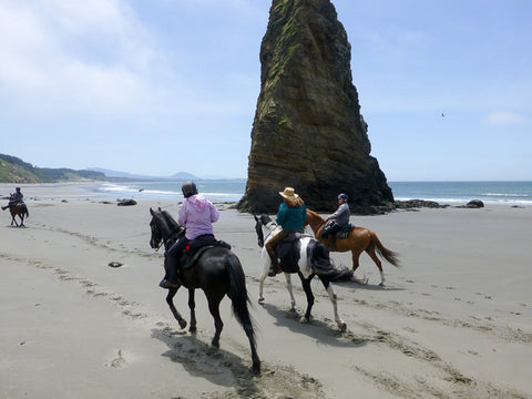 Riders go past The Needle at Cape Blanco State Park