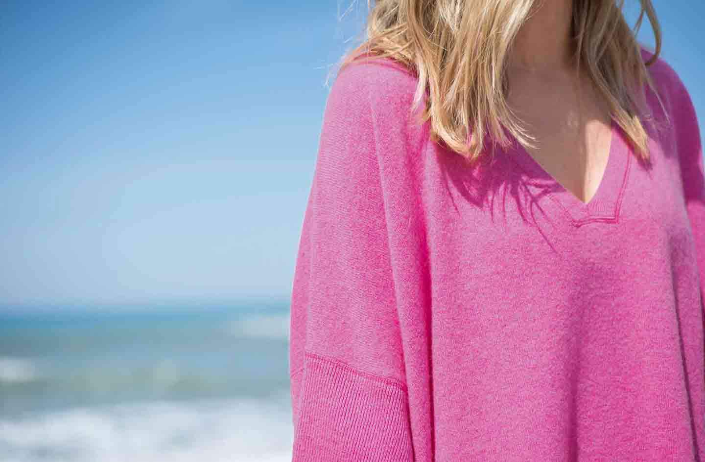 Women-standing-infront-of-the-sea-and-blue-sky-wearing-a-pink-cashmere-kimono-