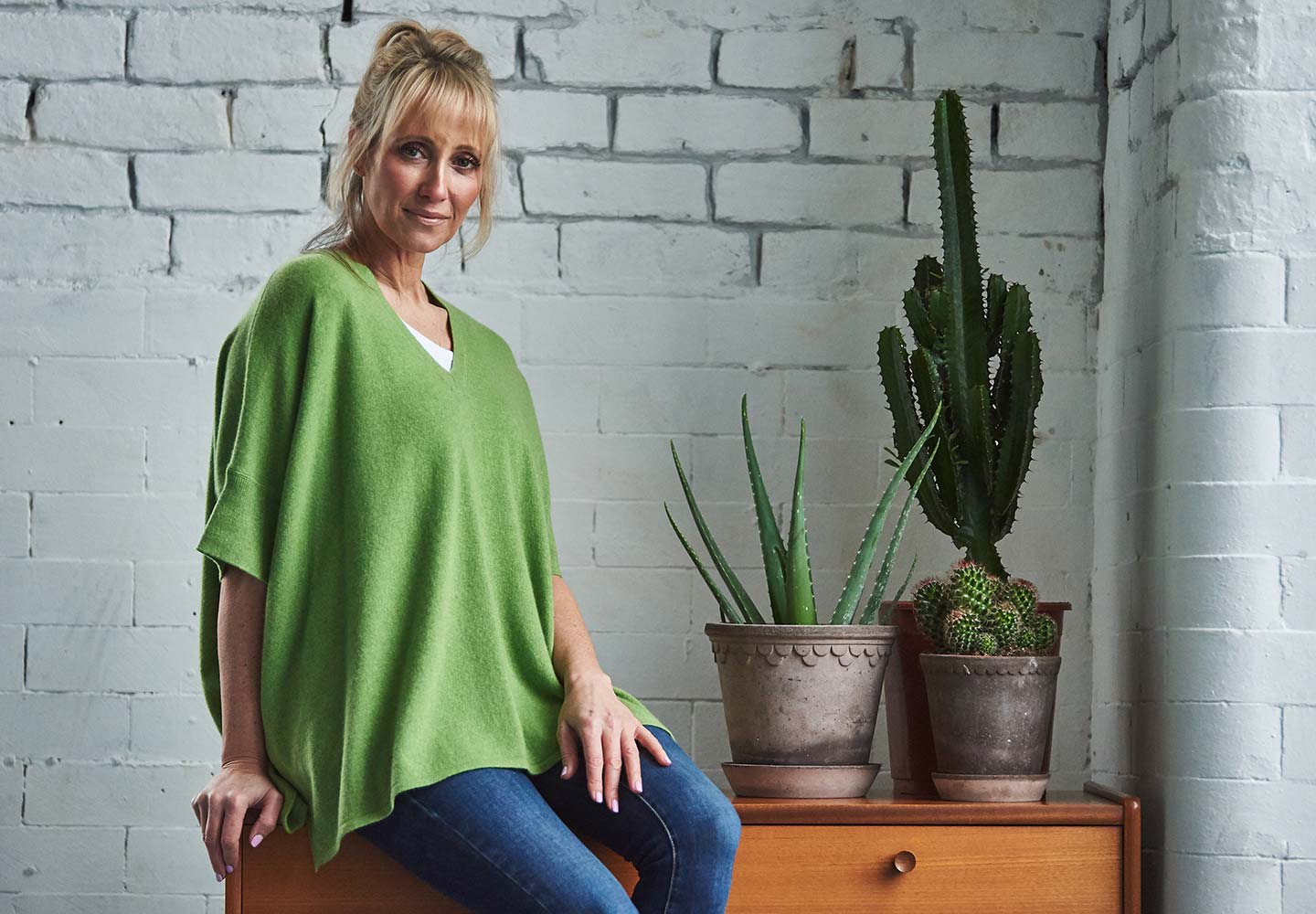 woman wearing green cashmere jumper and cactus