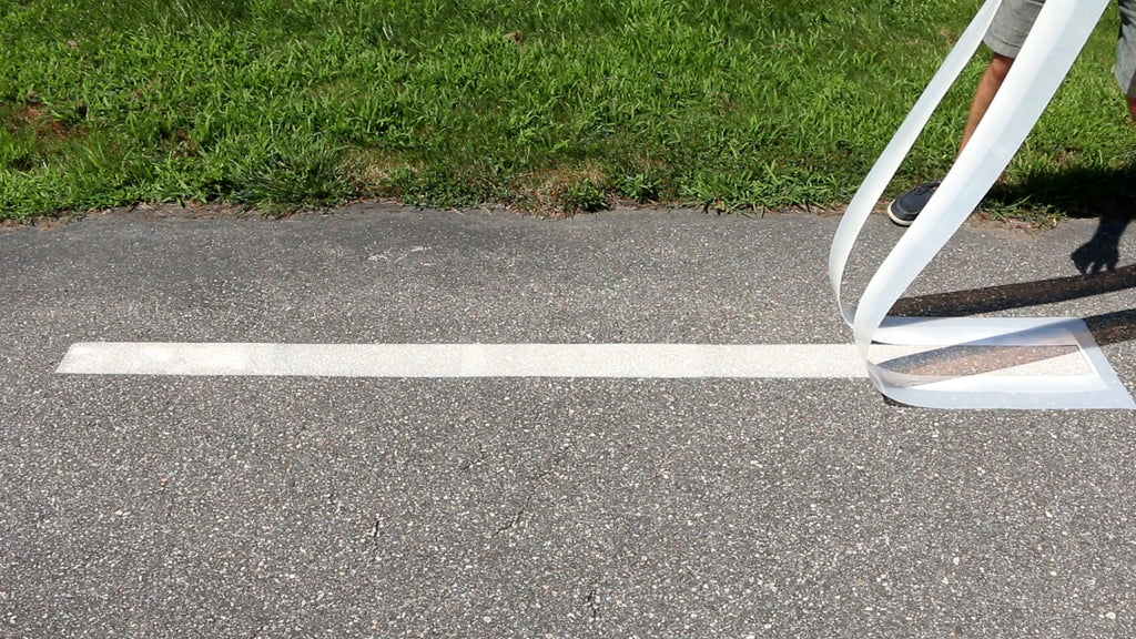 Remove the stencil by peeling it straight off of the pavement, making sure not to drag it