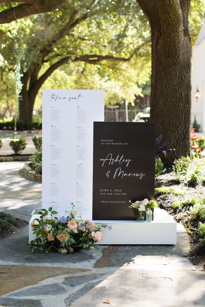 Black and white wedding signs on a white stand