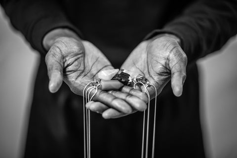 hands holding crystals and chains both stainless steel and sterling silver