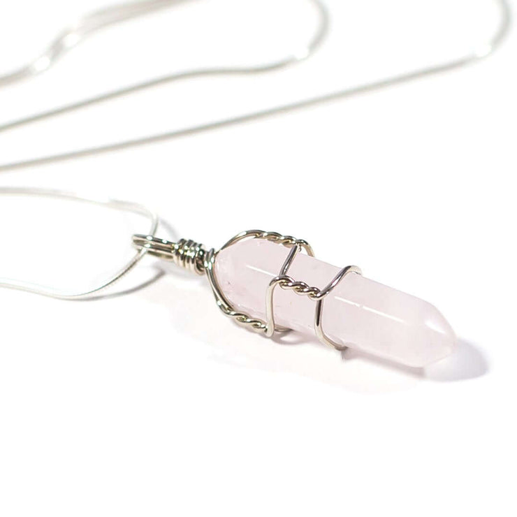 Close up side view of Love crystal Rose quartz wrapped bullet point pendant.