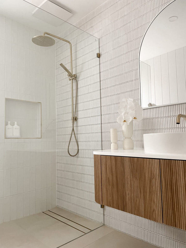 Modern bathroom with glass shower and wooden vanity.