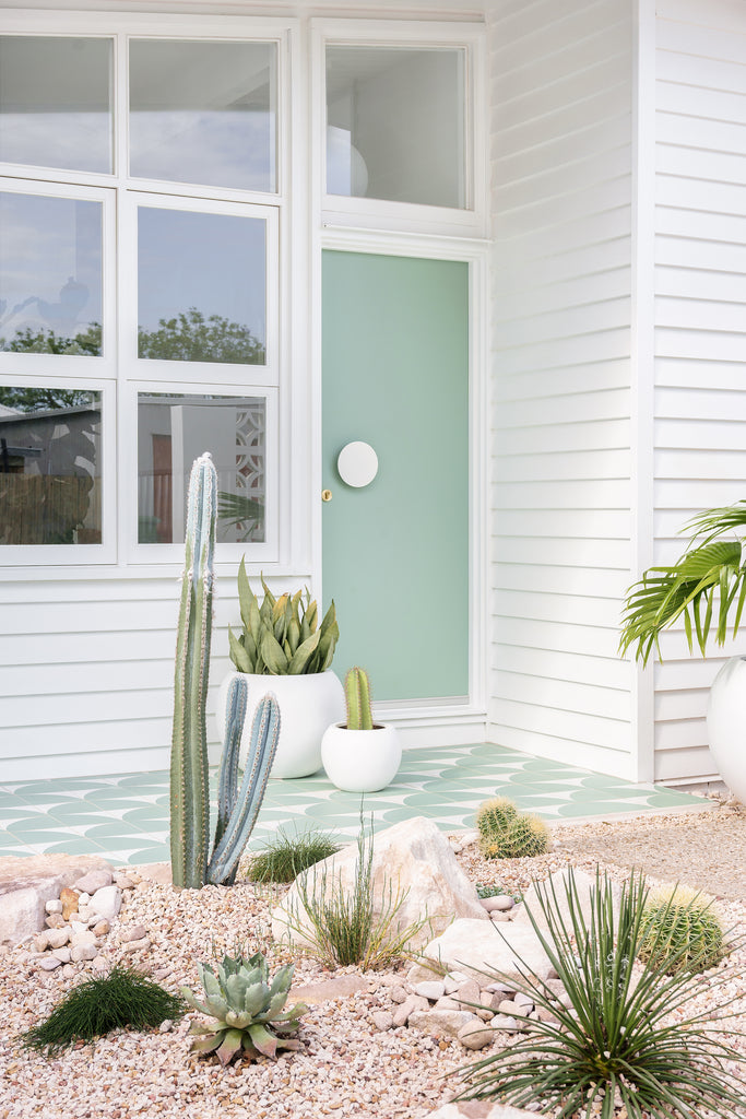 Green encaustic titles on front porch of a palm springs home with a green front door