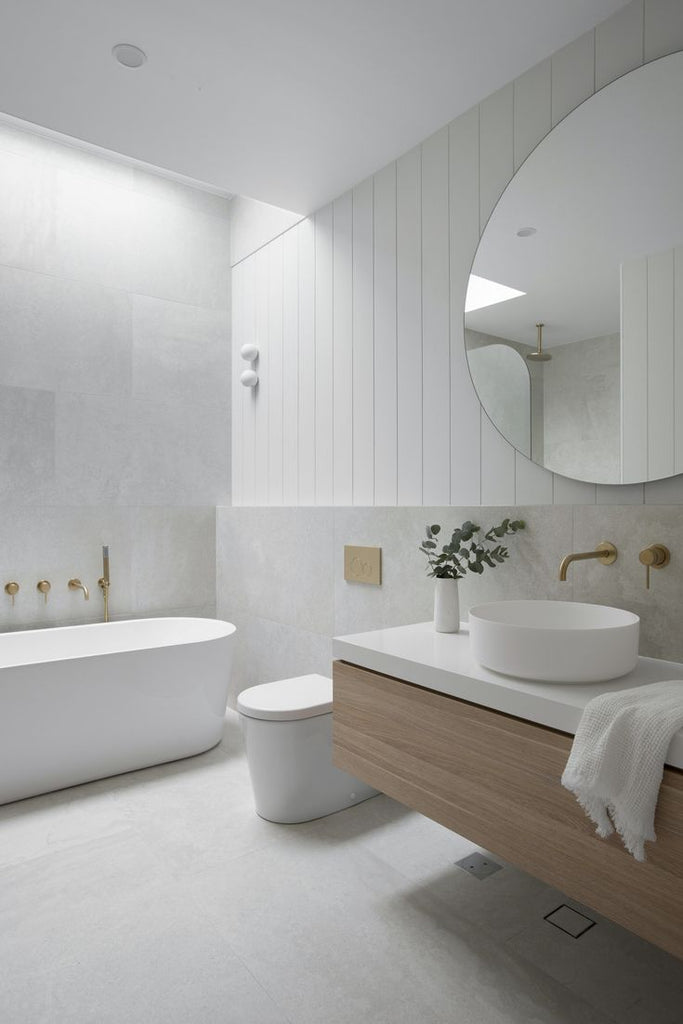 A contemporary bathroom featuring white walls and a stylish wooden vanity, offering a fresh and inviting atmosphere.