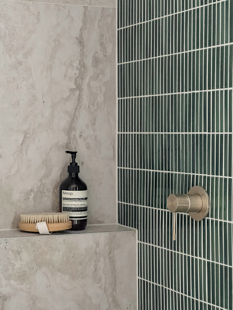 Stone look grey tiles in a shower with green kit kat tiles