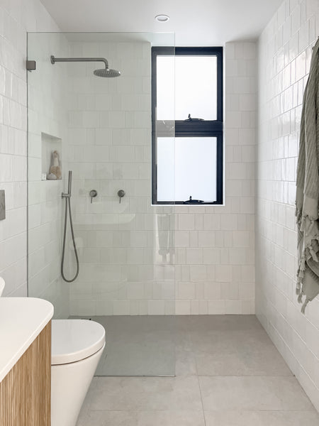 Tile bathroom with white wall tiles and grey floor tiles