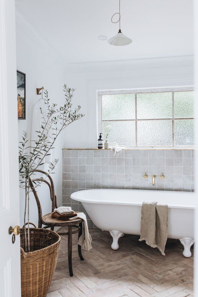 An inviting bathroom featuring a bathtub and a wooden chair, offering a serene space to unwind and rejuvenate.