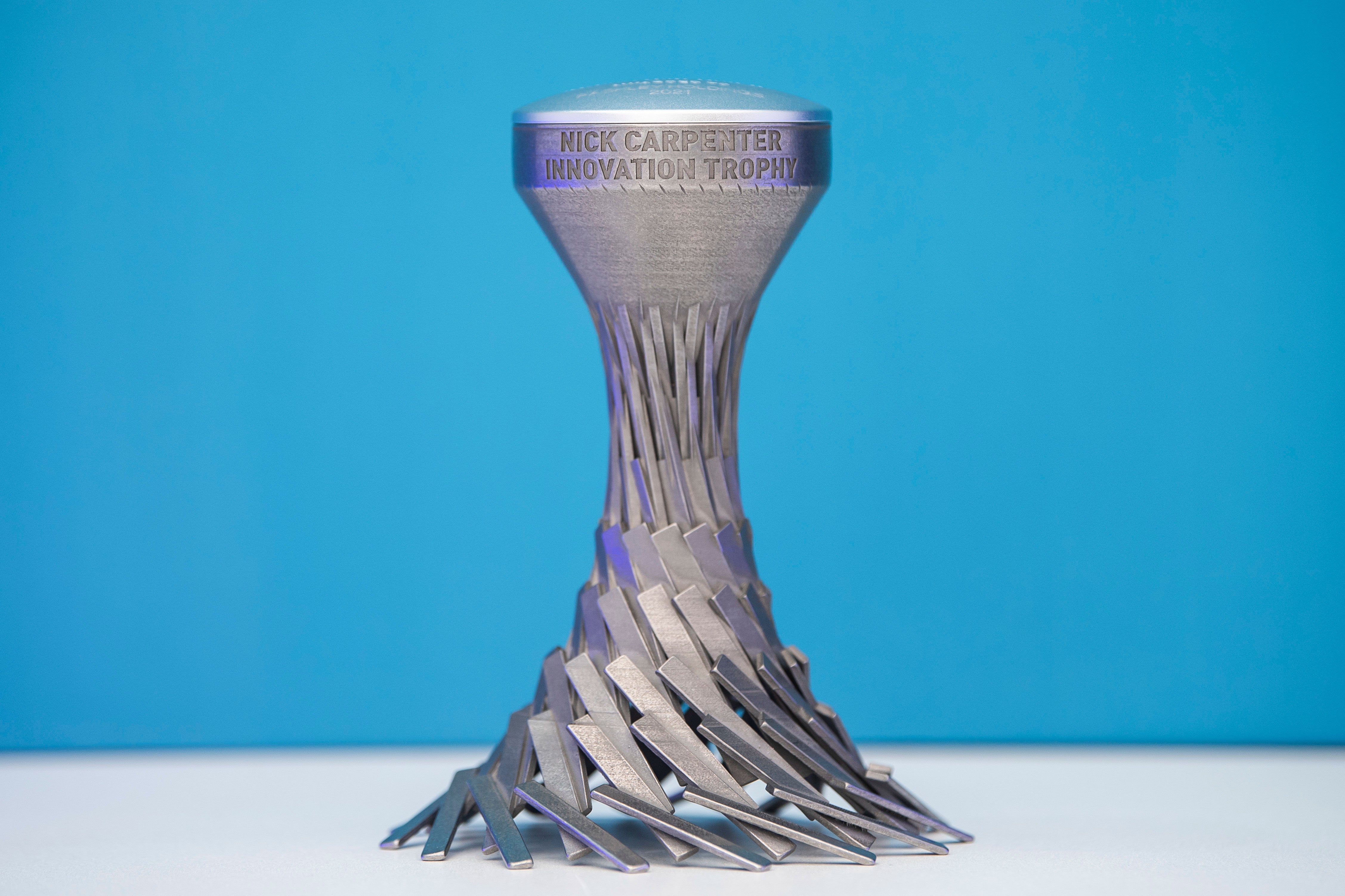 3D printed titanium trophy with sprialling base design, wider at the bottom and leading to a narrower top that is engraved.