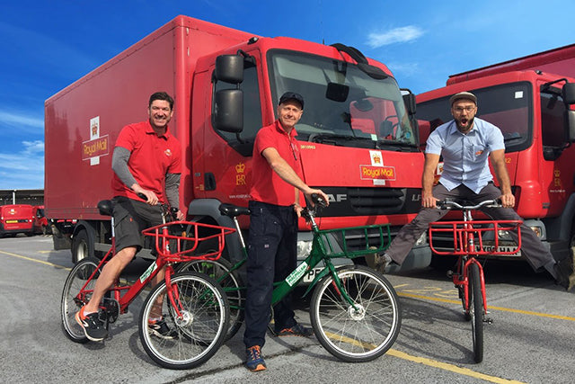 Postmen sat on their Pashley Pronto Mailstar bikes in front of a red Royal Mail lorry.