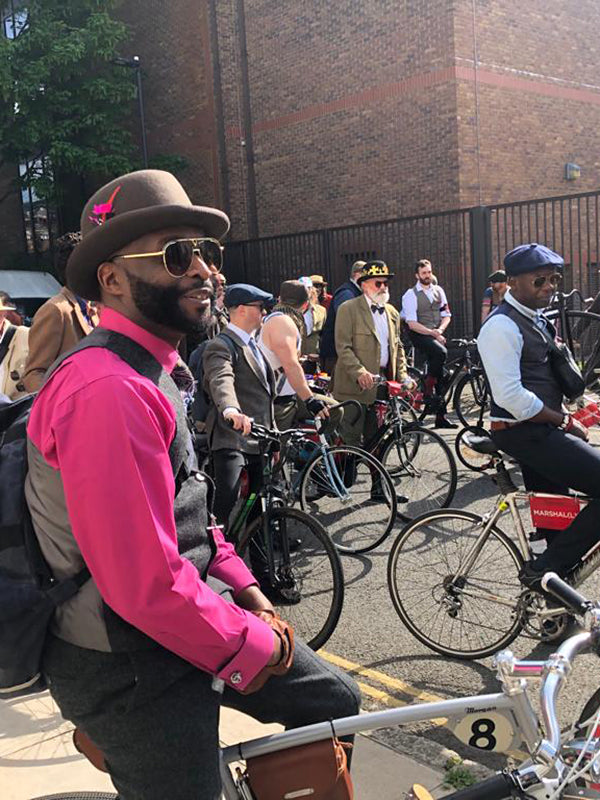 A gentleman in  bright pink shirt and tweed waistcoat sat on his British Pashley-Morgan bicycle at the London Tweed Run 2023.